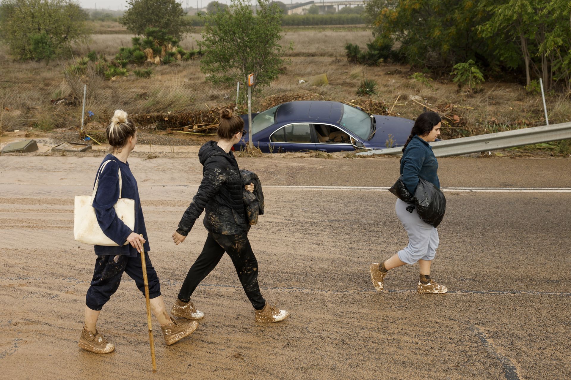 Tres personas caminan por la carretera de Valencia por las carreteras