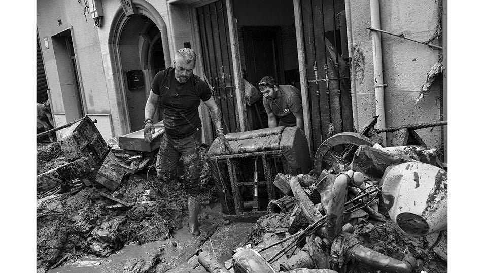 Un hombre intenta evaluar los daños mientras que limpia el barro del interior de su domicilio en Paiporta tras el devastador paso de la DANA