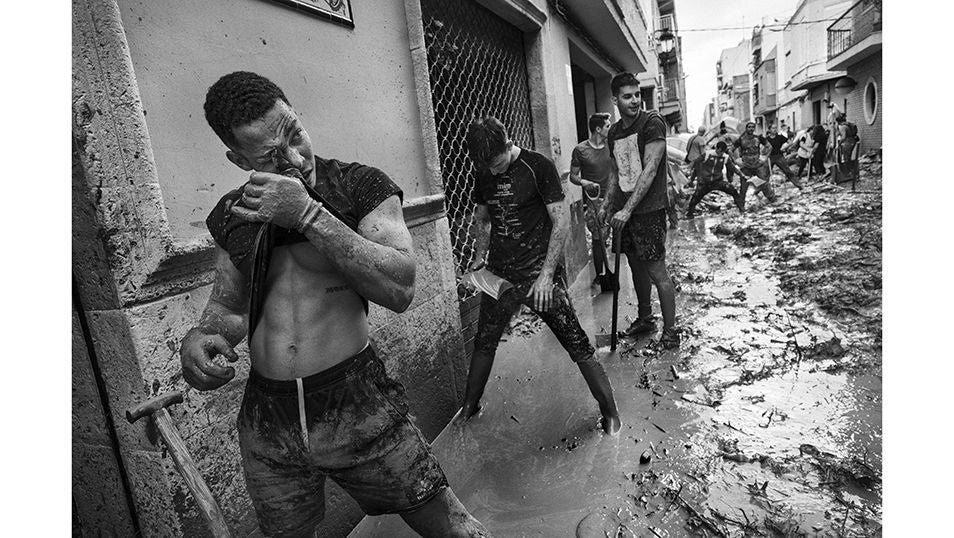 Voluntarios ayudan como pueden a retirar escombros, lodo y agua de las calles de Paiporta tras el paso de la DANA