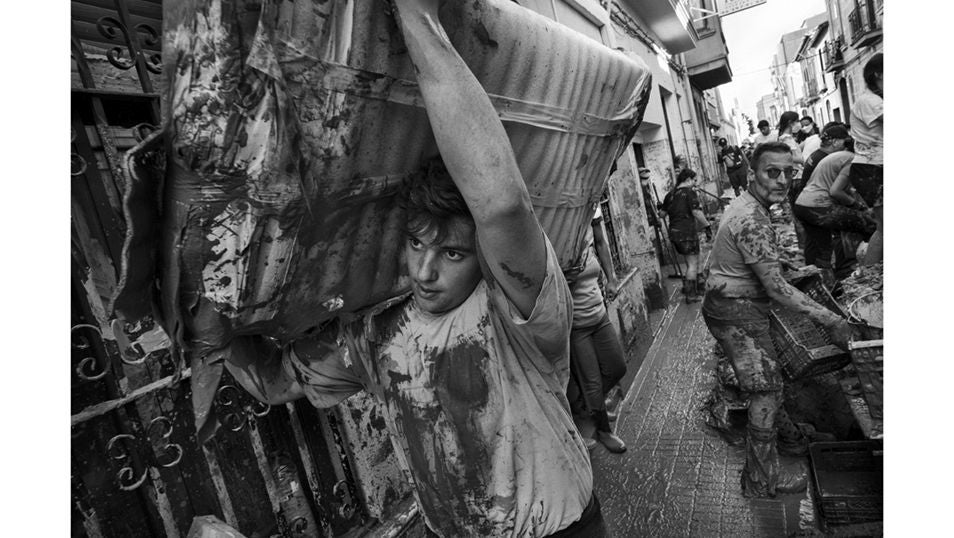 Un voluntario carga sobre su hombro restos de escombros en la localidad de Paiporta