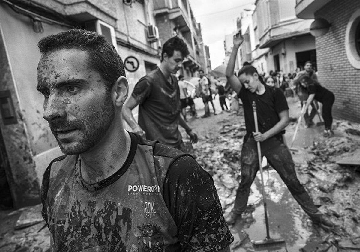 Voluntarios ayudan como pueden a retirar escombros, lodo y agua de las calles de Paiporta tras el paso de la DANA