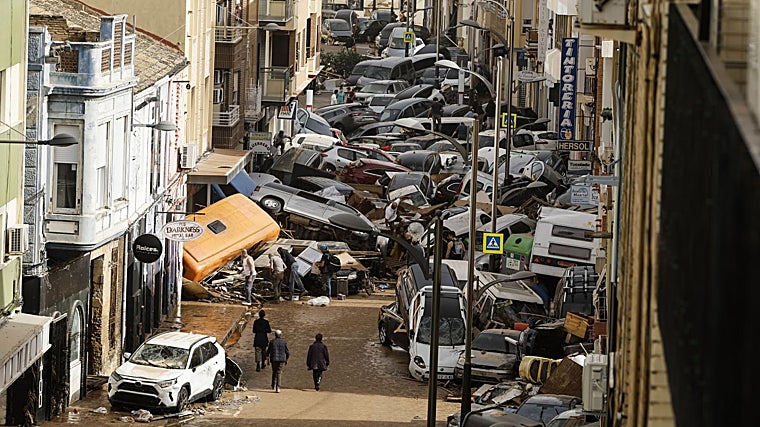 Vehículos amontonados en una calle tras las intensas lluvias de la fuerte en Picaña (Valencia)
