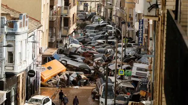 Before image - Cars stacked on Avenida Gómez Ferrer (Sedaví) before being removed by volunteers, neighbors and heavy machinery