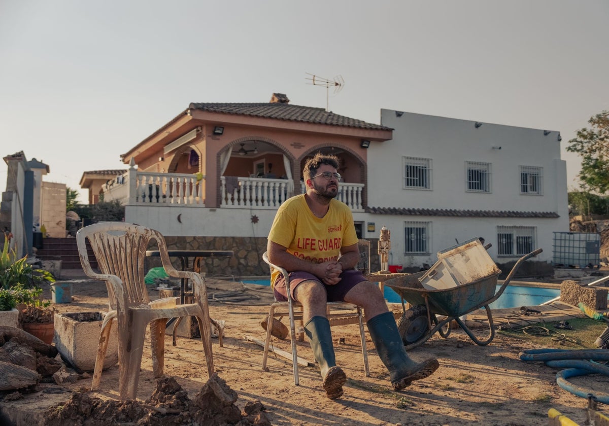 Jonathan, de 23 años, mira al barranco ante su casa, tras sobrevivir a la riada, hace una semana