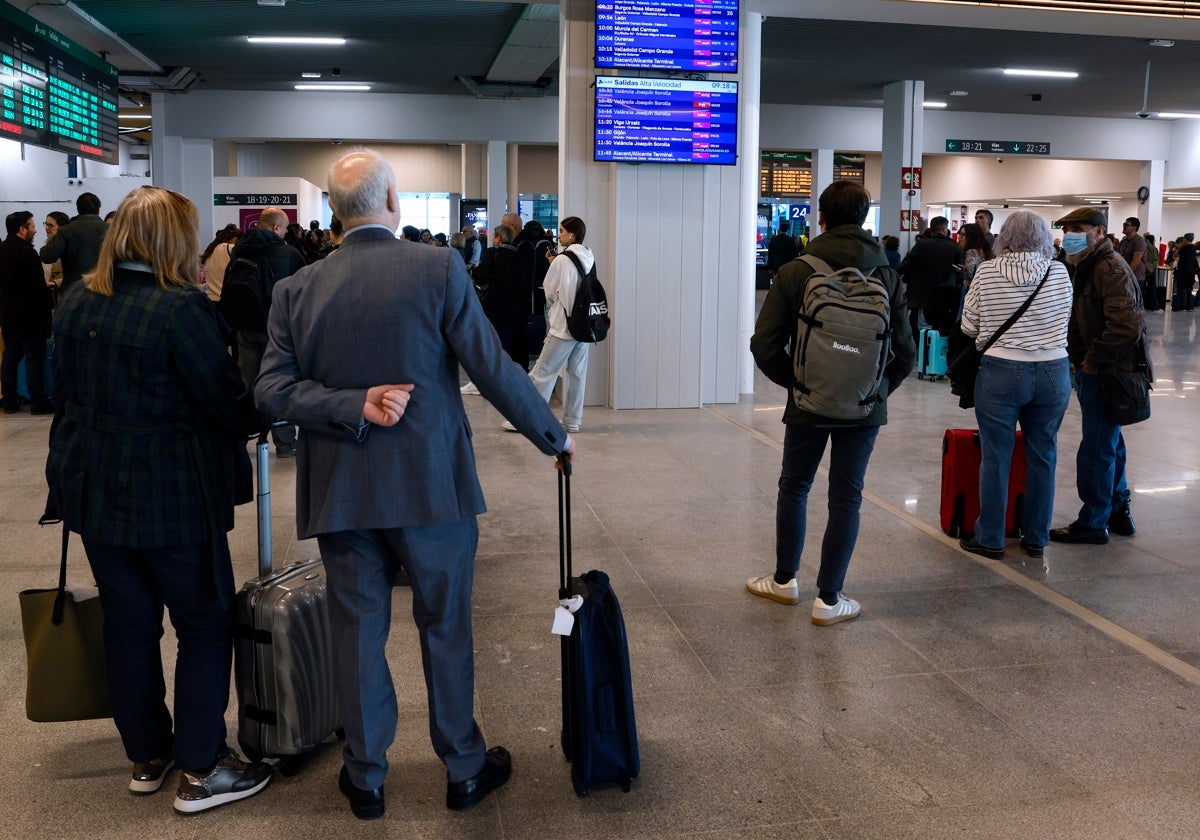 Varias personas aguardan para coger un tren