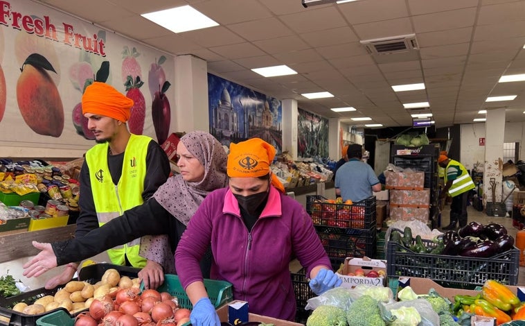 Imagen principal - Arriba, la frutería de Sedaví donde la comunidad sij reparte verduras y frutas gratuitas a la població. Debajo, un momento de la comida antes de comenzar el trabjao. En la última foto, Amrik Singh, el sij de Llançà (Gerona) que ha dejado sus negocios para ayudar en Valencia. Antes estuvo también en Ucrania.