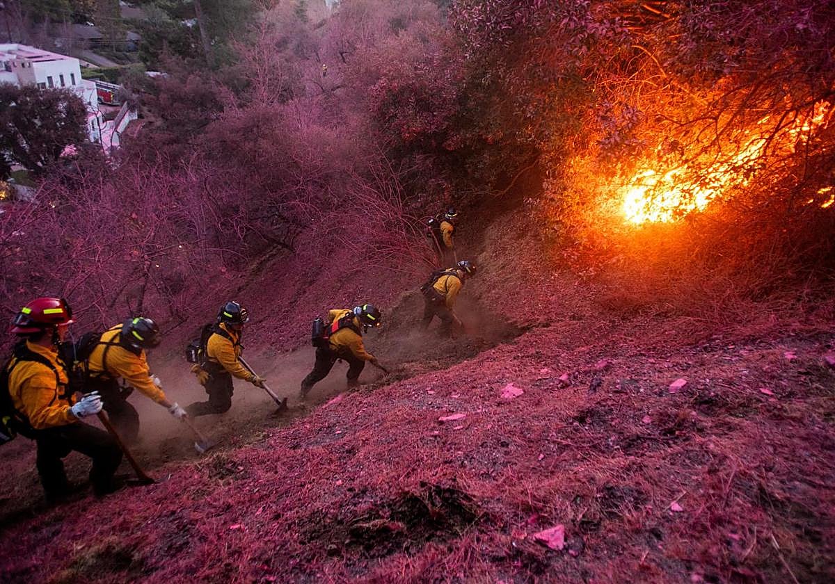 Los bomberos trabajan para despejar un cortafuegos en el incendio de Los Ángeles