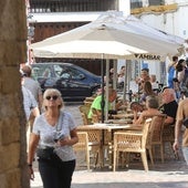 Terraza de un bar con sombrillas patrocinadas por Ambar en Córdoba