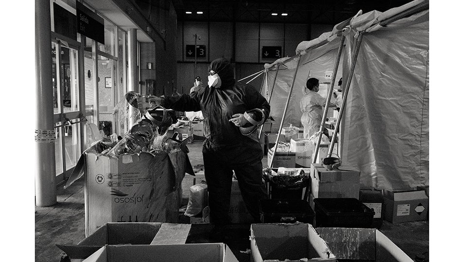 Un auxiliar de enfermería desinfecta todo el equipo de protección personal utilizado por los médicos y enfermeros que trabajan en la zona sucia del pabellón 5 del hospital de campaña de IFEMA.Ante la presión asistencial en los centros médicos de la Comunidad de Madrid, el gobierno regional buscó descongestionar las hospitalizaciones instalando un hospital de campaña para tratar a pacientes con COVID-19 en una de las mayores áreas vacías de la capital española. En 48 horas, el recinto ferial de IFEMA en Madrid se convirtió en el mayor hospital de campaña temporal para COVID en España.