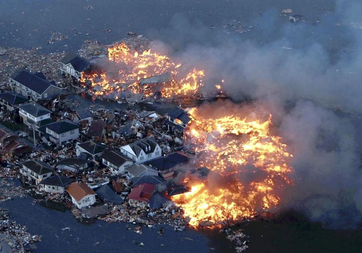 Casas en llamas mientras el río Natori se desborda sobre los alrededores por las marejadas del tsunami en la ciudad de Natori, en el tsunami que afectó Japón en 2011