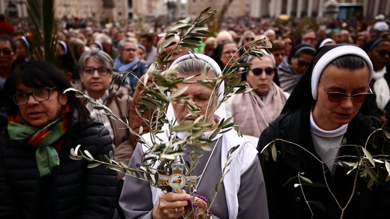 Dos religiosas sostienen sus ramos en la plaza de San Pedro