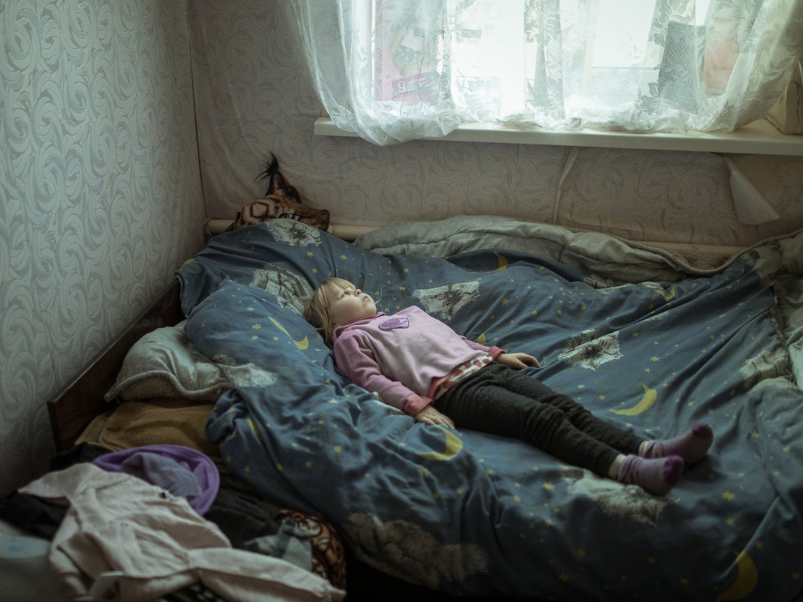 Una niña ucraniana de seis entumecida sobre la cama por los ataques de pánico que sufre como consecuencia de la guerra.