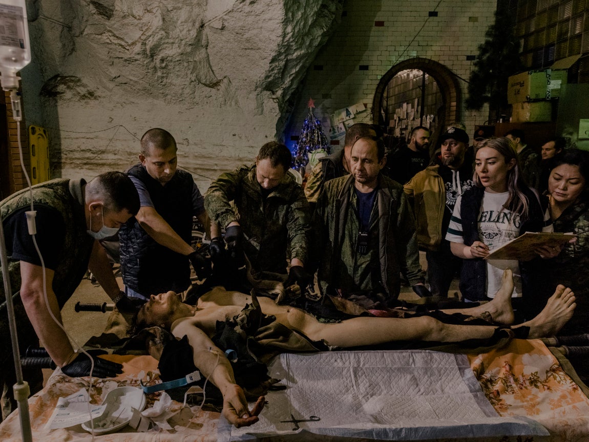 Un hombre ucraniano de la región de Luhansk, reclutado para luchar por las fuerzas separatistas respaldadas por Rusia, que luego se fusionaron con el ejército ruso, yace herido en un hospital de campaña instalado en una bodega subterránea cerca de Bajmut