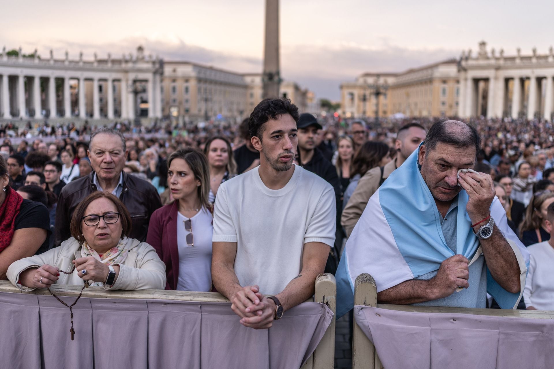 Miles de personas acuden a despedir al Papa en la plaza de San Pedro. Un hombre con la bandera de Argentina no puede contener las lágrimas.