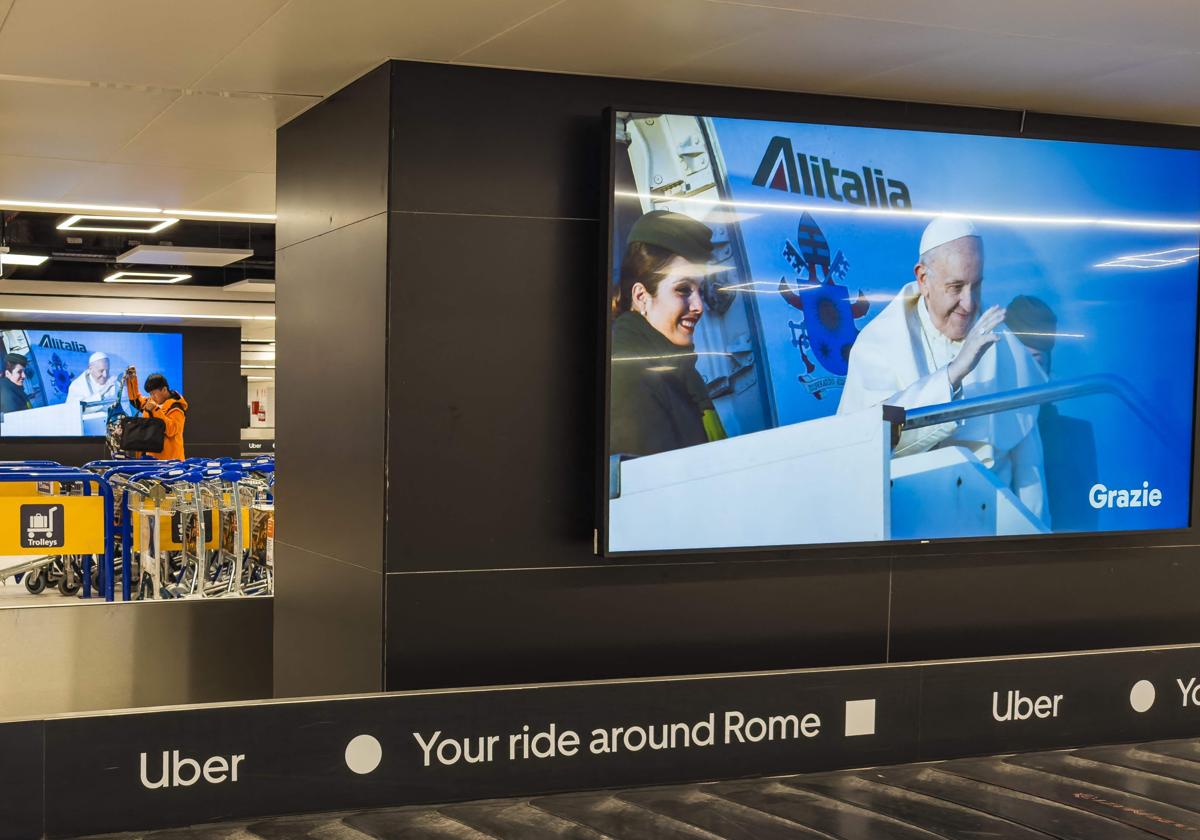 El aeropuerto de Fiumicino, en Roma, con un cartel de recuerdo al Papa Francisco
