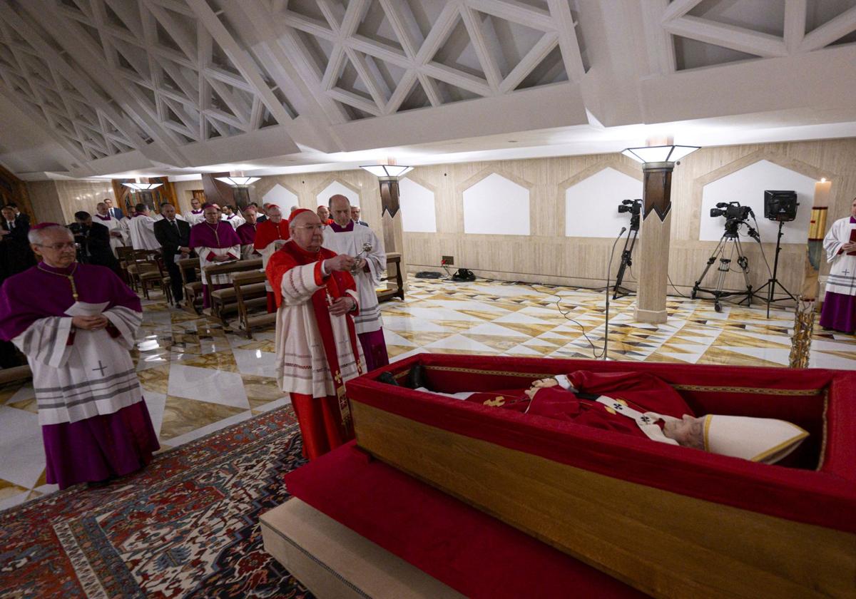 El cardenal Kevin Joseph Farrell bendice el cuerpo del Papa Francisco, colocado en un ataúd abierto durante el rito de la declaración de fallecimiento en Santa Marta