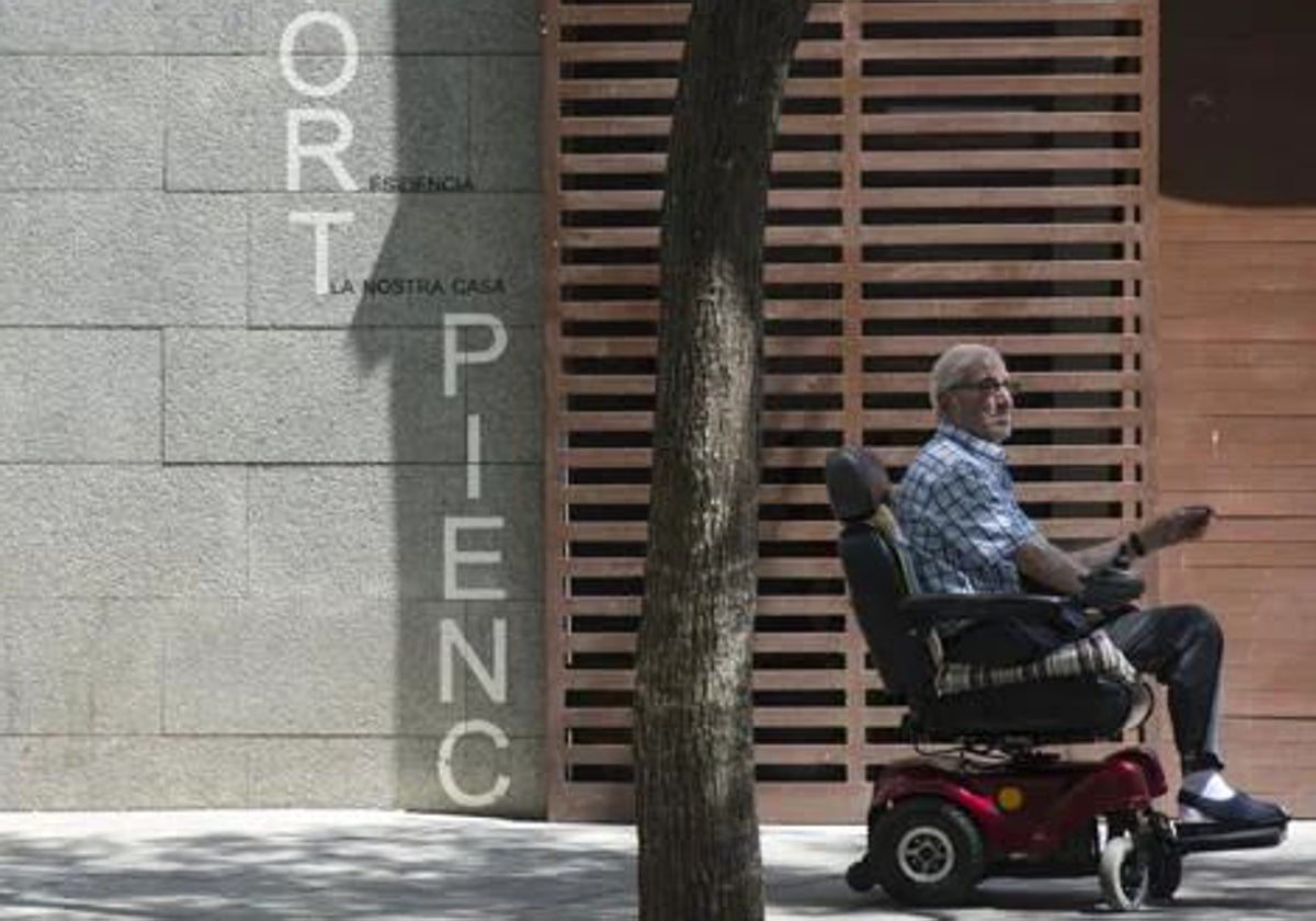 Un anciano en la puerta de una residencia de Barcelona
