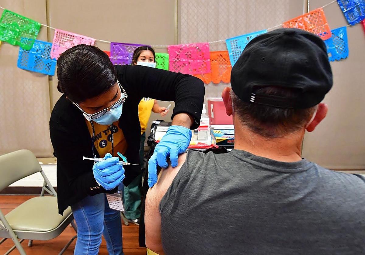 Una enfermera vacunando a un paciente contra el covid
