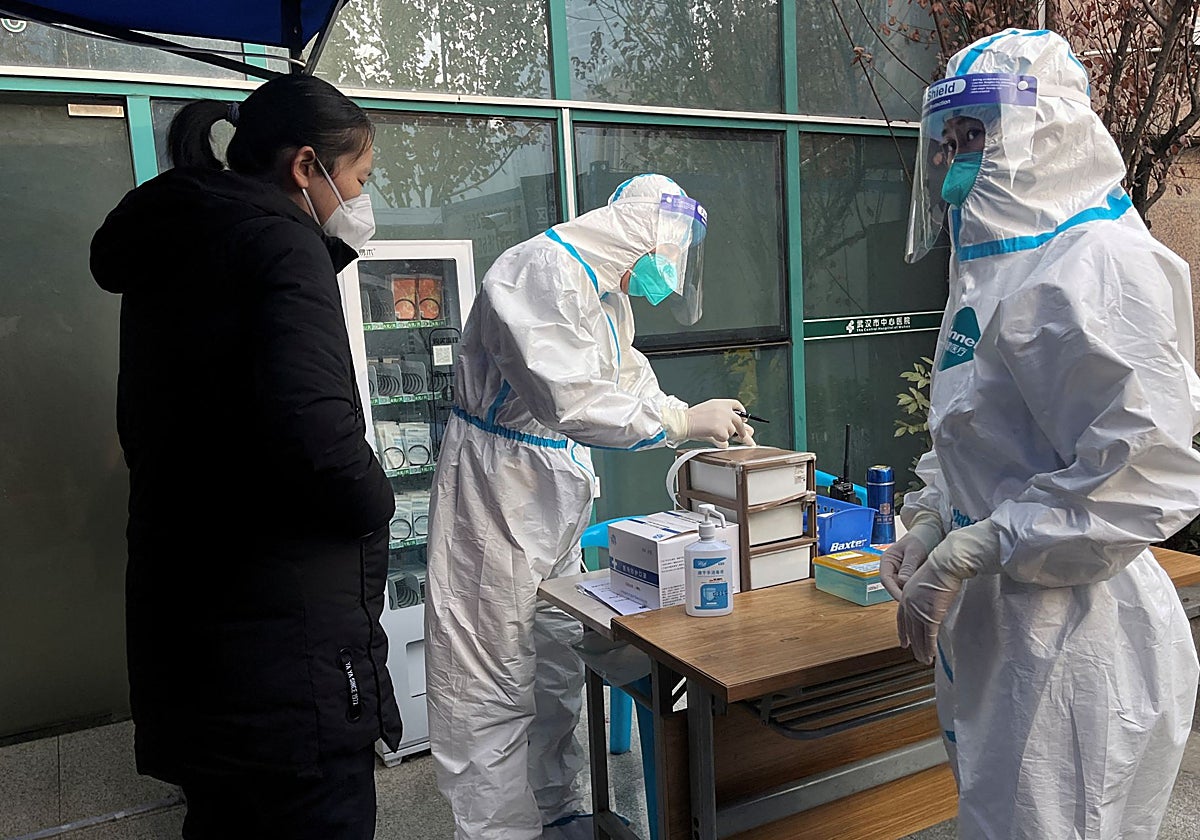 Un trabajador médico con traje de protección registra la información de un paciente en China, en una imagen de archivo