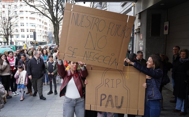 Imagen principal - Arriba, una manifestación en Bilbao como consecuencia de la fusión de dos centros. En la imagen intermedia, el cartel del colegio Txurdinaga, en la capital de Vizcaya, que se fusionará el curso que viene con el Pío Baroja por falta de estudiantes.