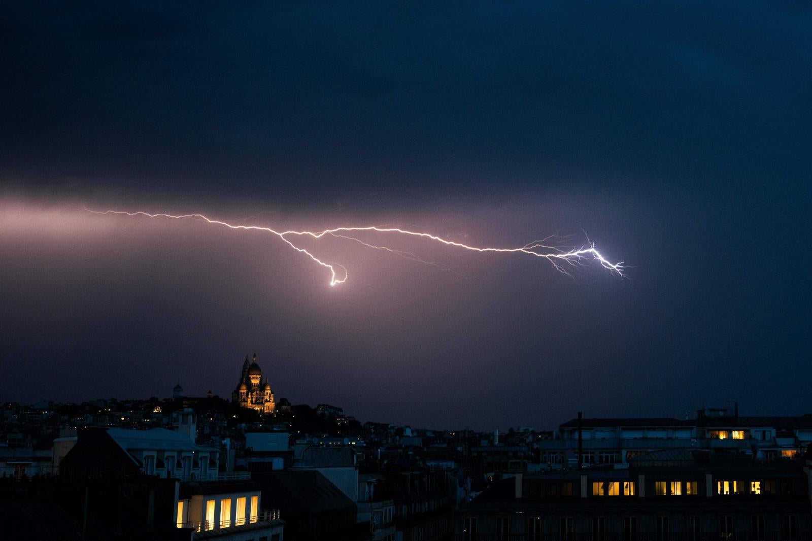 Un rayo ilumina el cielo sobre la basílica del Sagrado Corazón en Montmartre durante una tormenta eléctrica, al norte de París