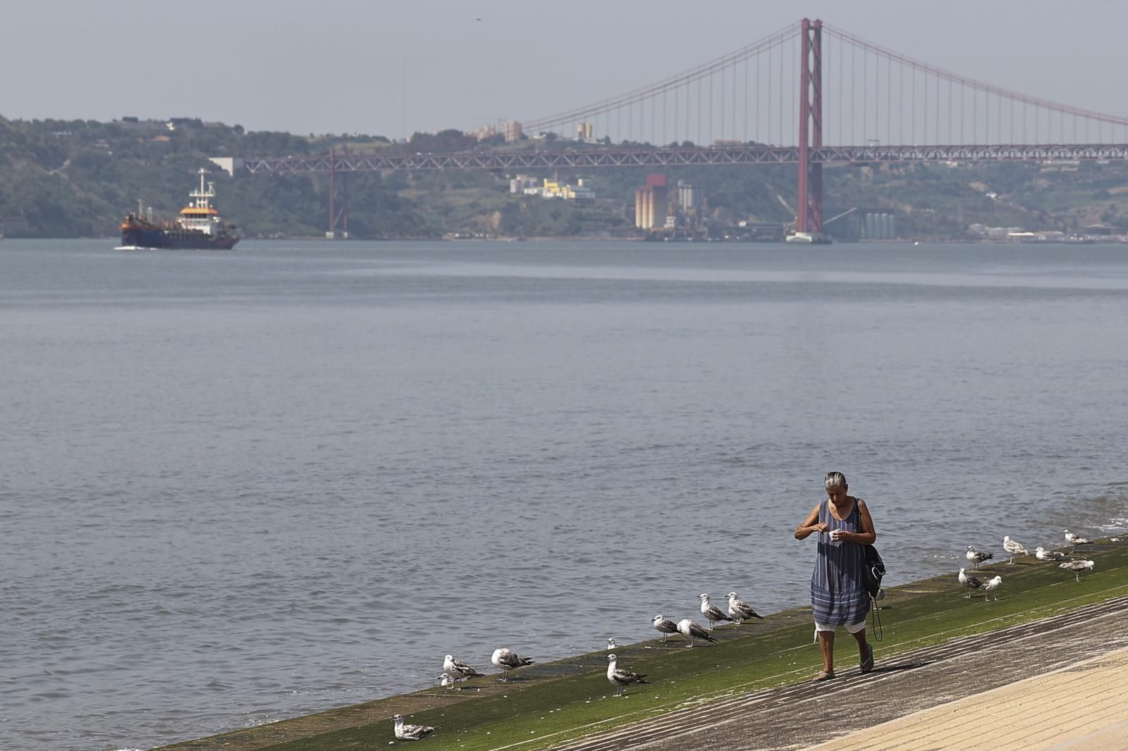 Una mujer pasea junto al río Tajo en Lisboa, Portugal.