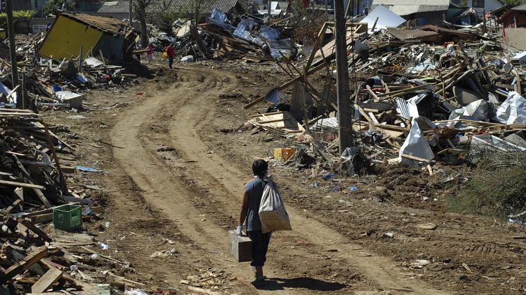Una persona camina junto a edificios derrumbados en Chile, tras el terremoto de 8,8 que azotó el país en el 2010