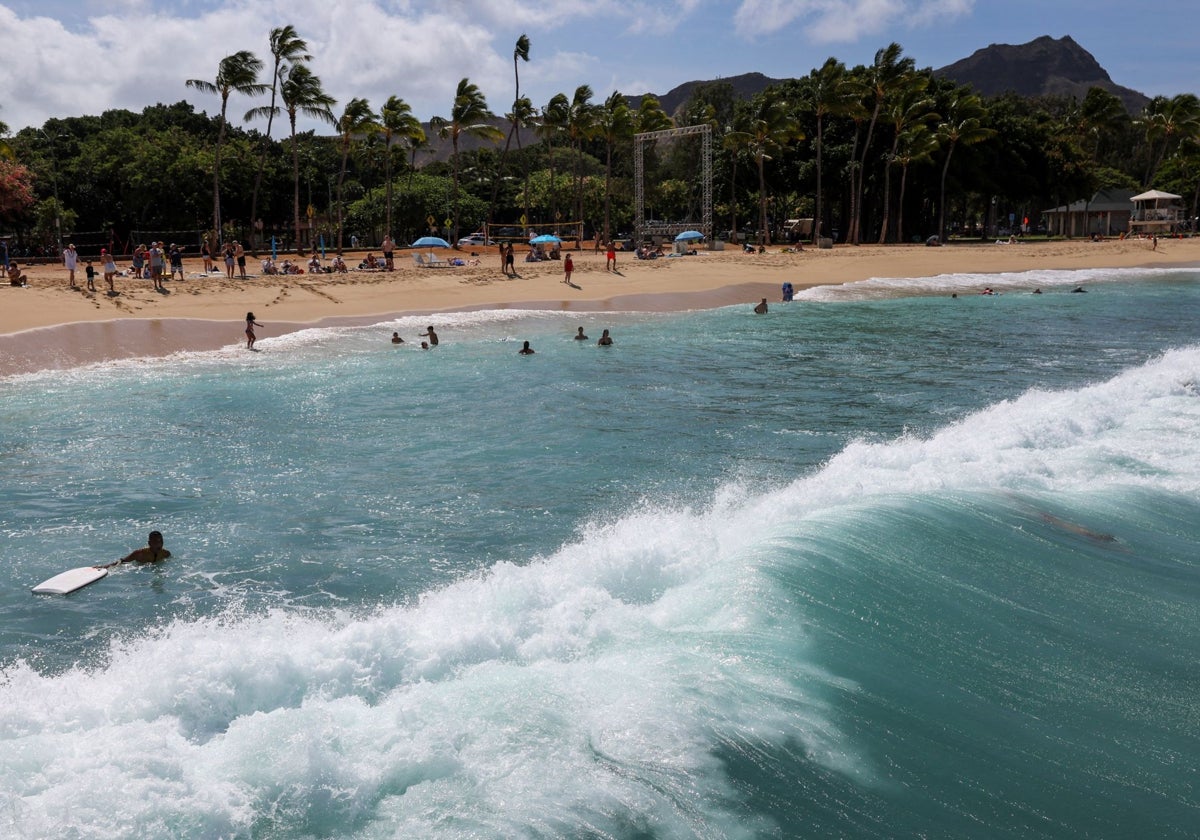 Los vacacionistas regresan a las playas después de que se rebajaran las alertas de tsunami en Honolulu