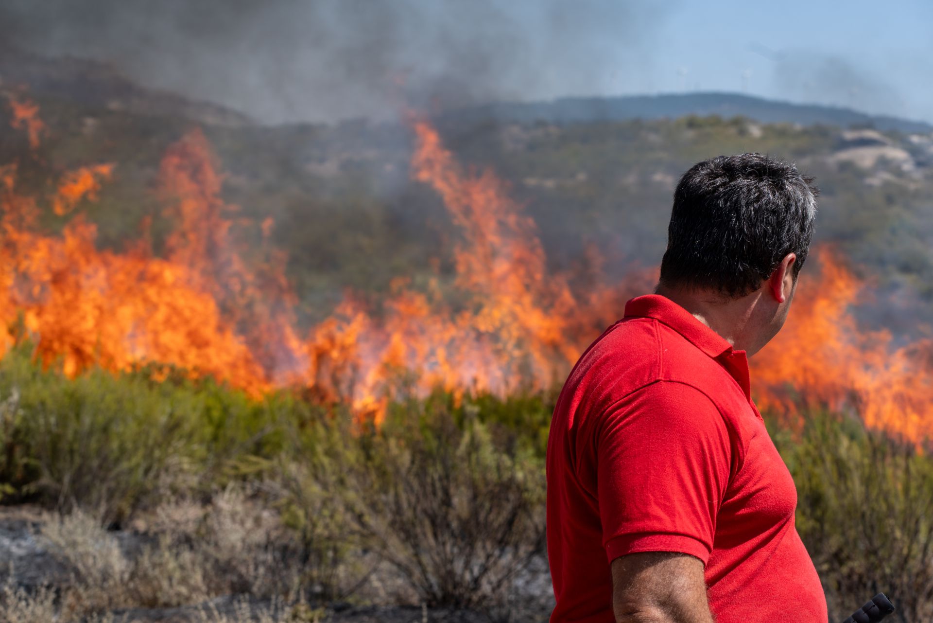 Un vecino de Cádavos observa las llamas desde las afueras de su pueblo