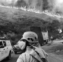 Las llamas avanzan ladera abajo mientras los equipos de extinción se preparan para contener el frente desde la carretera