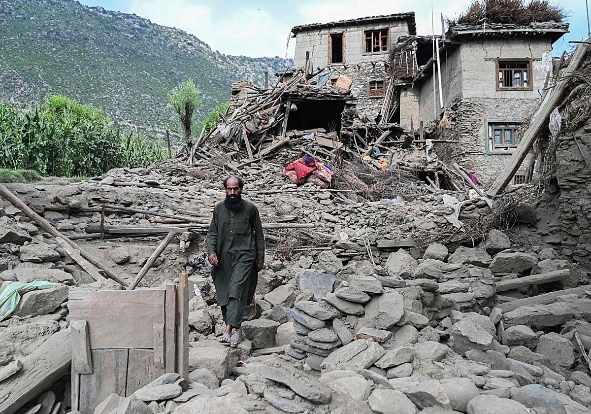 Un hombre afgano pasa junto a una casa dañada tras los terremotos en la aldea de Mazar Dara, en Nurgal, un distrito de la provincia de Kunar