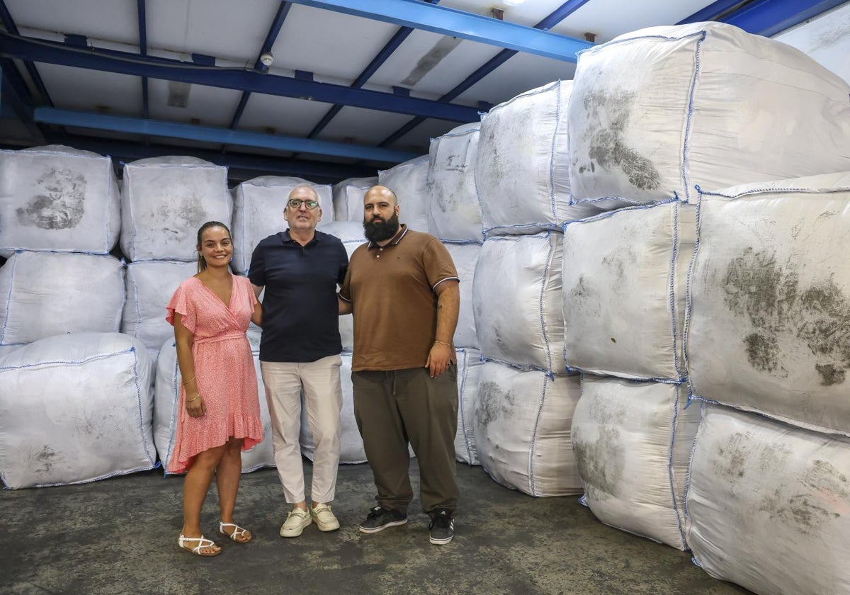 El gerente Félix Sánchez(centro) junto a dos empleados del almacén de Cáritas Mallorca en el polígono de Son Castelló de Palma donde se gestiona la recogida de ropa usada