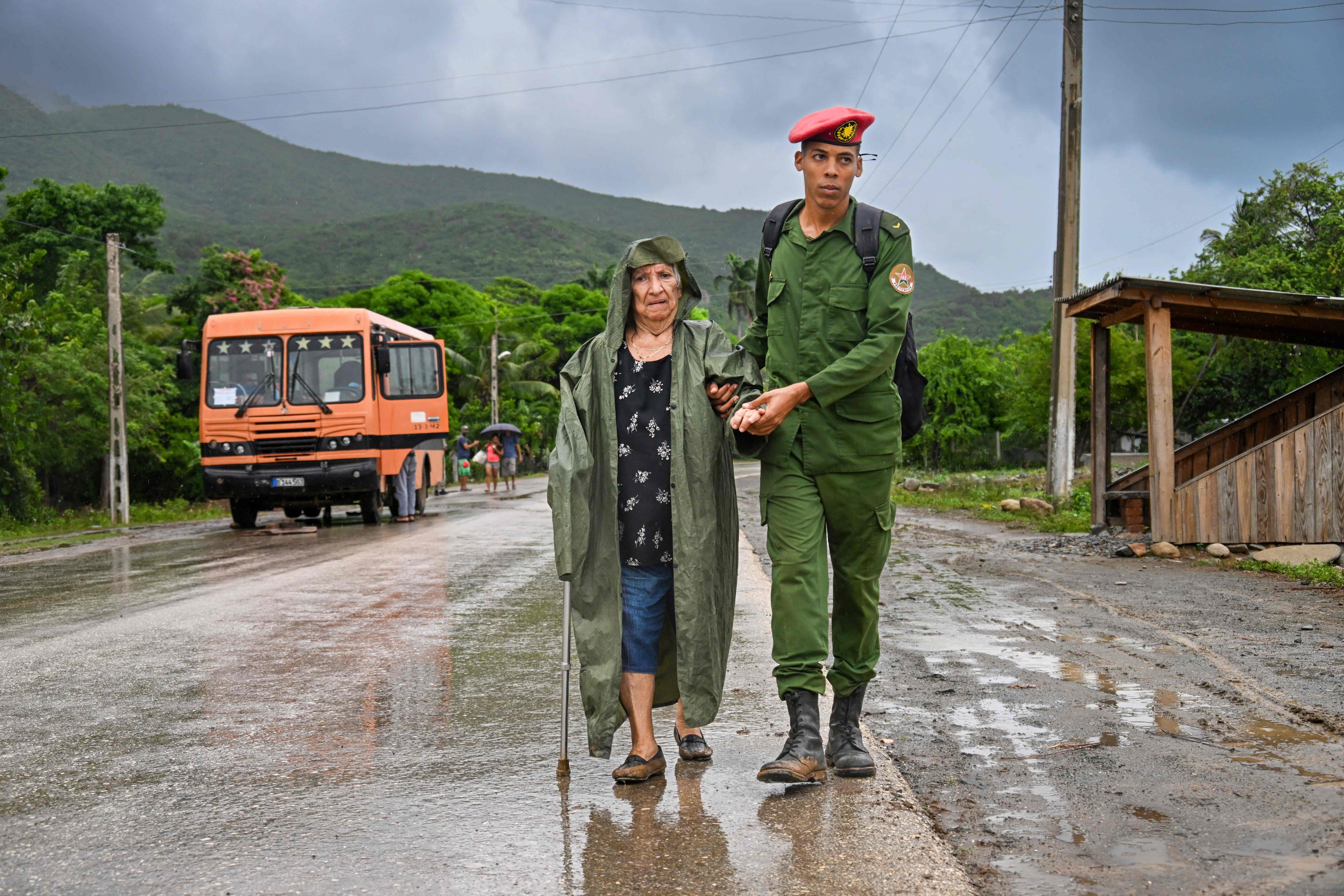 Un soldado ayuda a evacuar a una anciana a un lugar seguro antes de la llegada del huracán Melissa a la playa Siboney, en Santiago de Cuba, Cuba, el 28 de octubre de 2025.