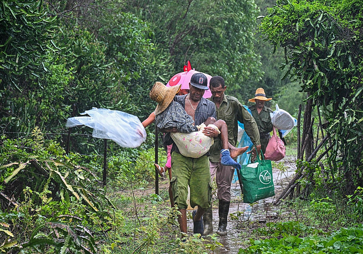 Soldados ayudan a evacuar a una ancianos hasta un lugar seguro antes de la llegada del huracán Melissa a la playa Siboney, en Santiago de Cuba, Cuba, el 28 de octubre de 2025.