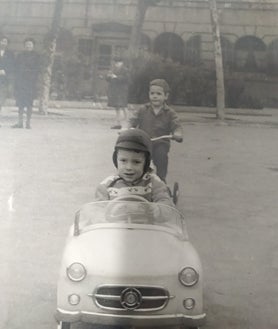 Imagen secundaria 2 - En la imagen superior, la entrada del cementerio este viernes, preparada para las visitas de los fieles difuntos de este fin de semana. Debajo, la casa en la que viven vista desde la valla exterior del cementerio. En la última foto, Marc con una bicicleta sigue a su hermano mayor, en un coche, en uno de sus juegos en el patio del cementerio 