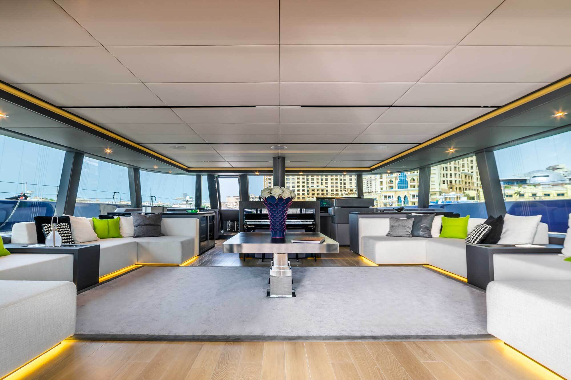 Dentro de la cabina de popa, los huéspedes disfrutan de un espacio de relajación con sofás, una mesa de comedor y una plataforma de baño.