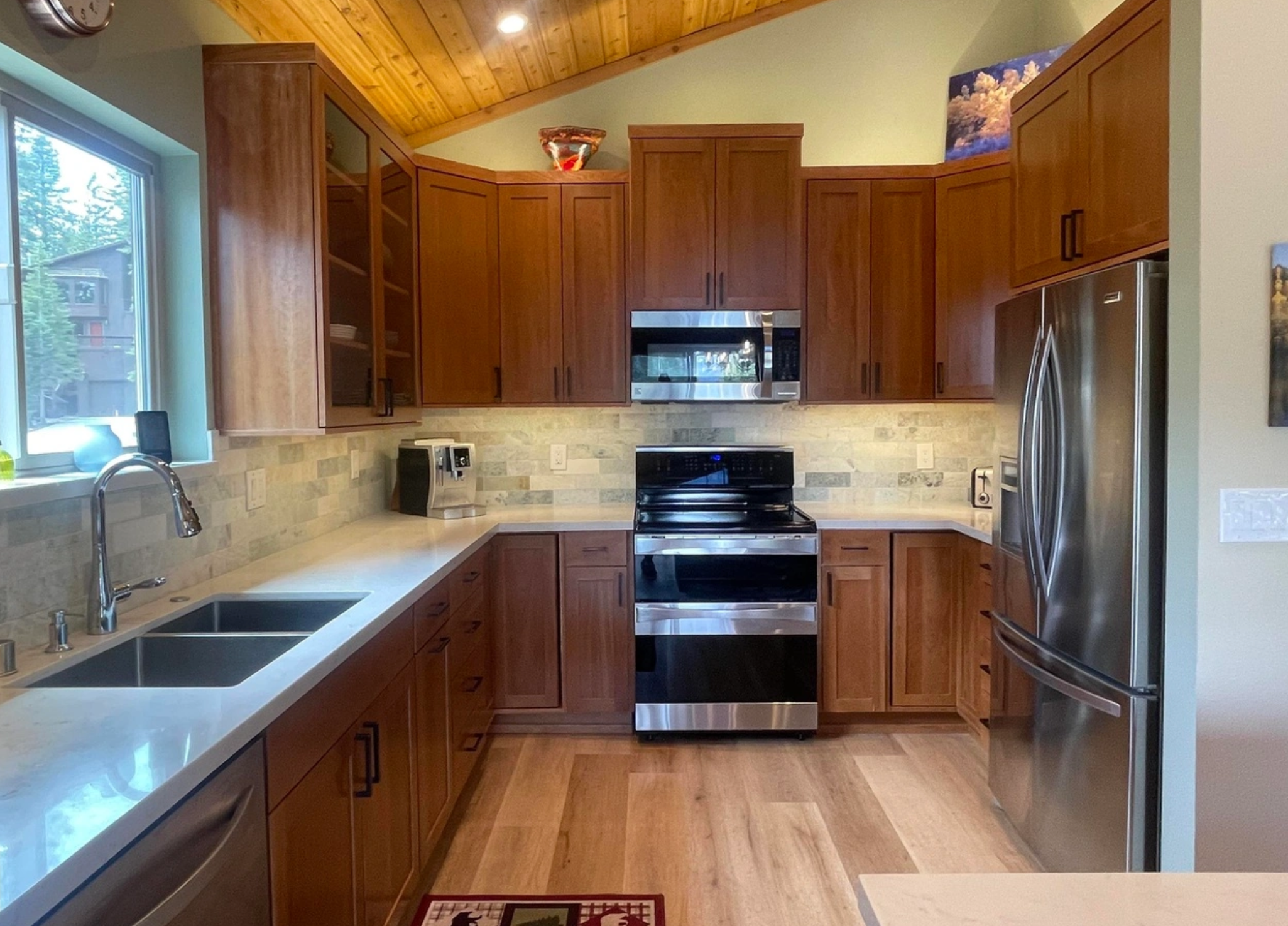 La cocina tiene encimeras de cuarzo, gabinetes personalizados de madera y electrodomésticos de acero inoxidable