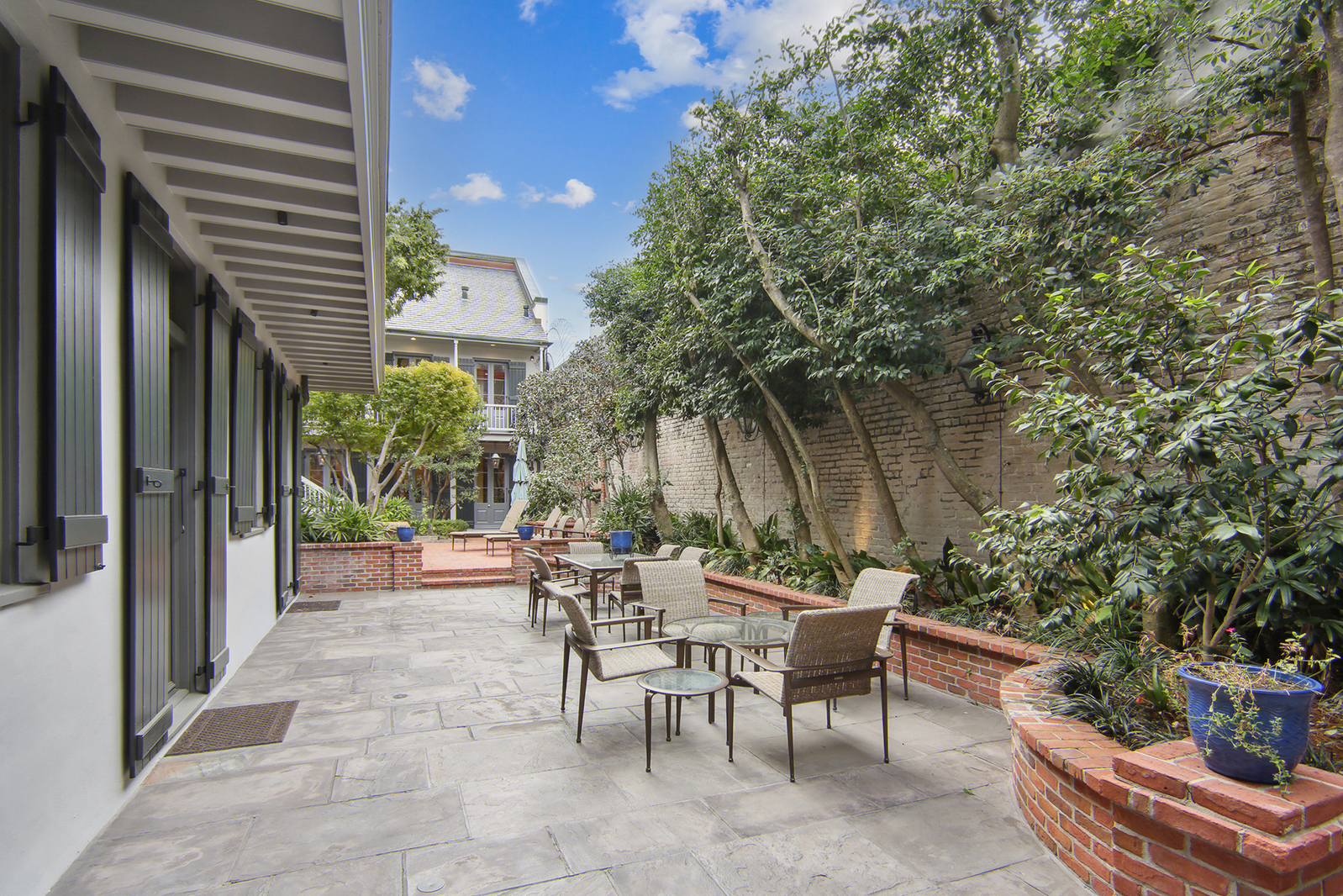 La zona exterior que se muestra como un coqueto refugio cuenta con zona de comedor al aire libre con varias mesas y sillas y una fuente