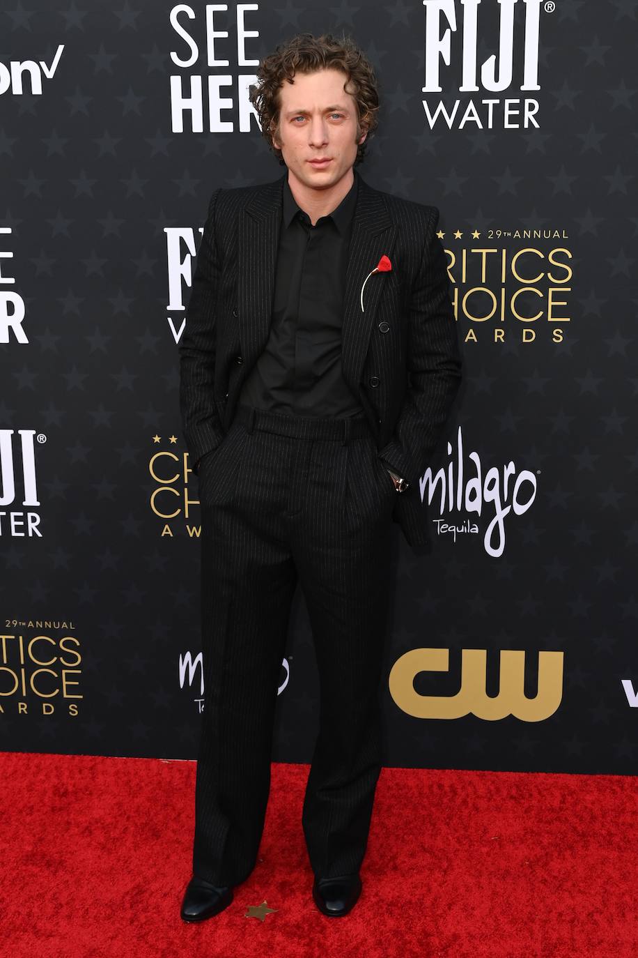 Jeremy Allen con un traje de chaqueta con ralla diplomática y pantalón ancho, todo ello de Saint Laurent y con un detalle en la solapa que ha dado mucho que hablar. 