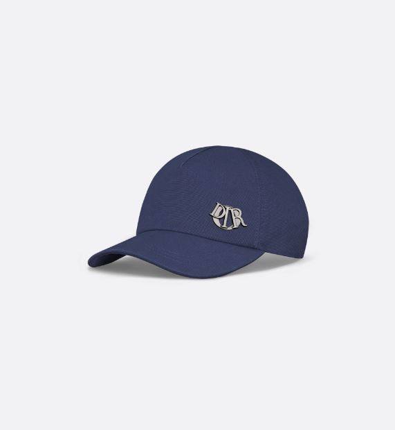 Esta gorra de algodón azul marino, novedad de la temporada verano 2024, presenta una firma Dior Charm de metal con acabado en rutenio inspirada en la emblemática firma de la Maison. La prenda moderna y casual realzará cualquier conjunto informal. Su precio es de 550 euros.