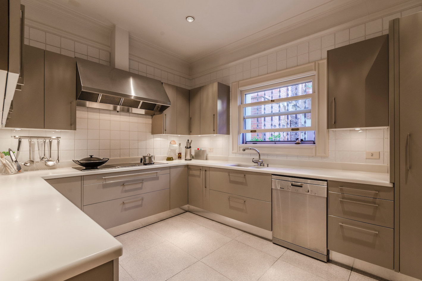 La cocina cuenta con gabinetes de color gris y electrodomésticos de acero inoxidable de alta gama