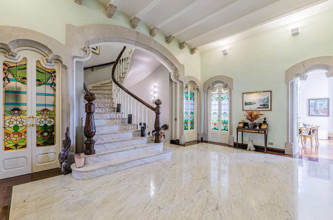 El vestíbulo muestra suelos de mármol, techos altos y una escalera circular que da paso a exquisitas estancias 