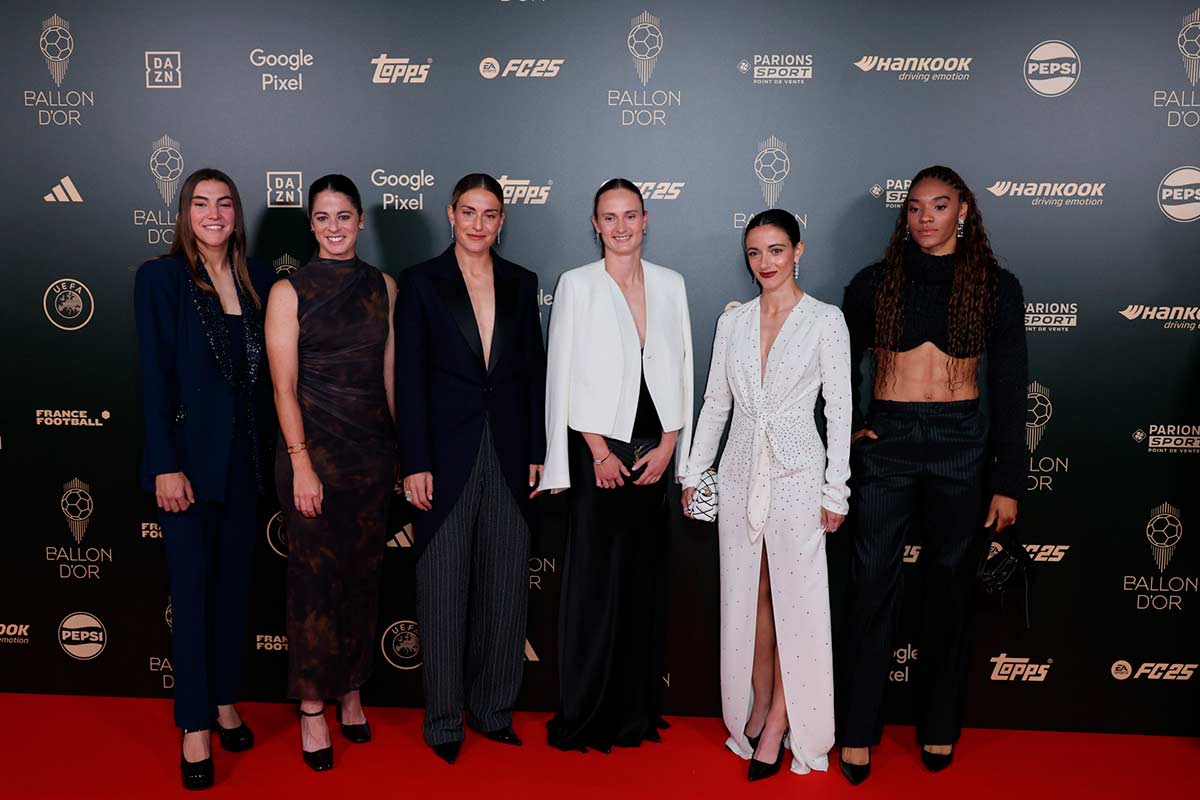 Varias futbolistas femeninas, entre ellas Aitana Bonmatí, que lleva un vestido blanco muy elegante. 