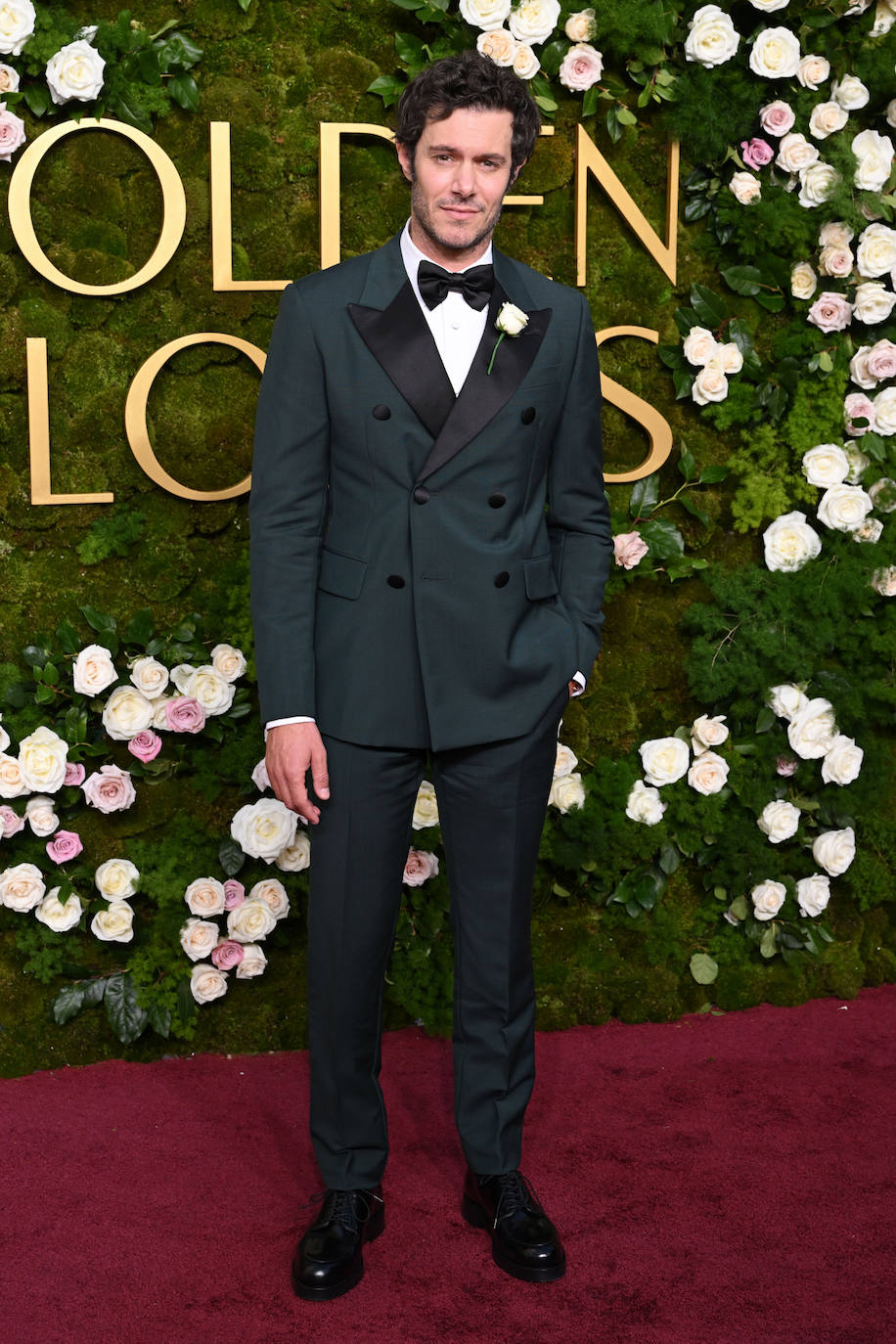 Adam Brody con un elegante esmoquin verde oscuro de Prada. 