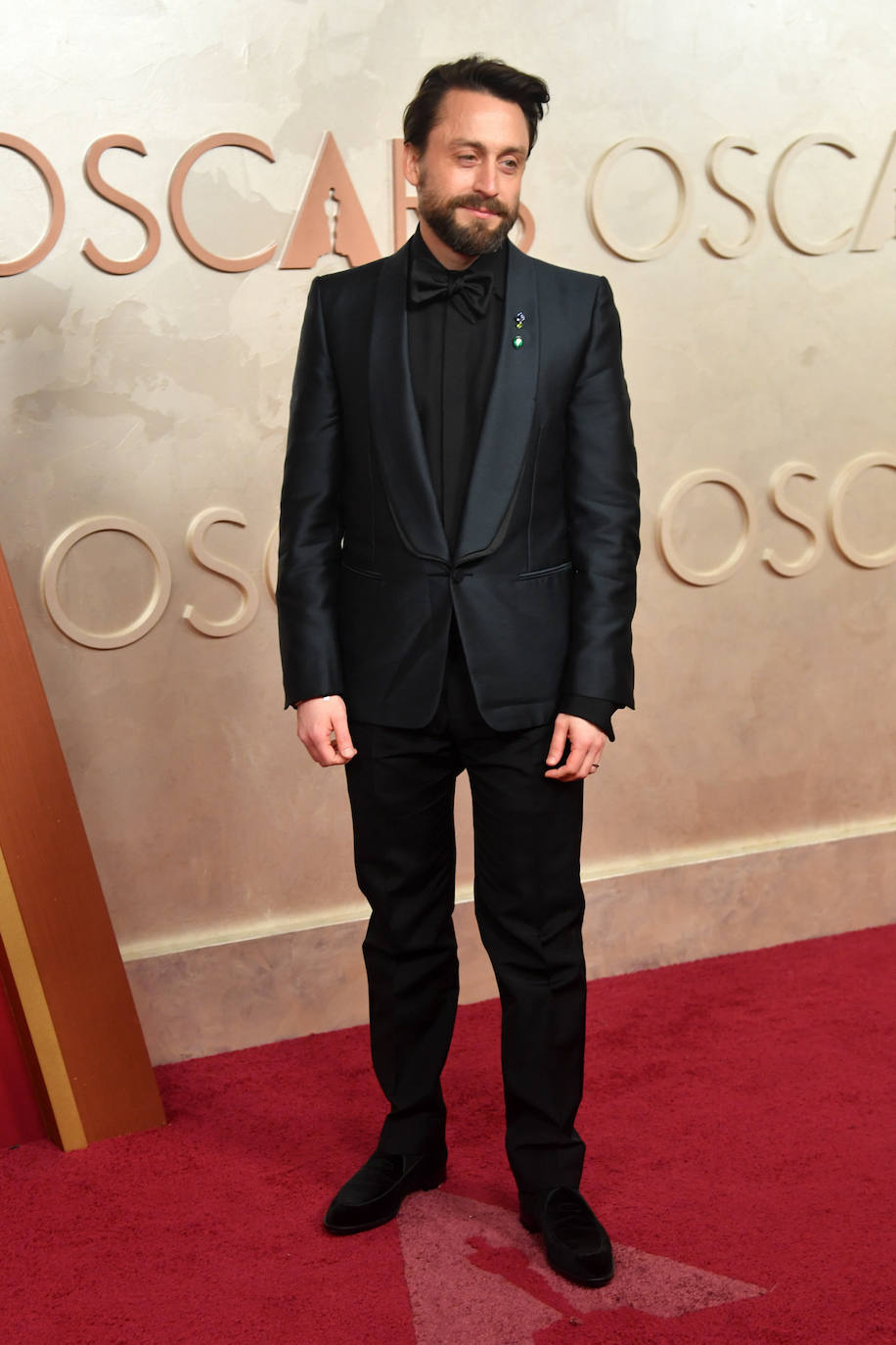 Kieran Culkin posó con un look de Zegna formado por una chaqueta de esmoquin de seda verde oscuro, una camisa de seda negra, pantalones de lana de mohair negros y una pajarita de satén negra.