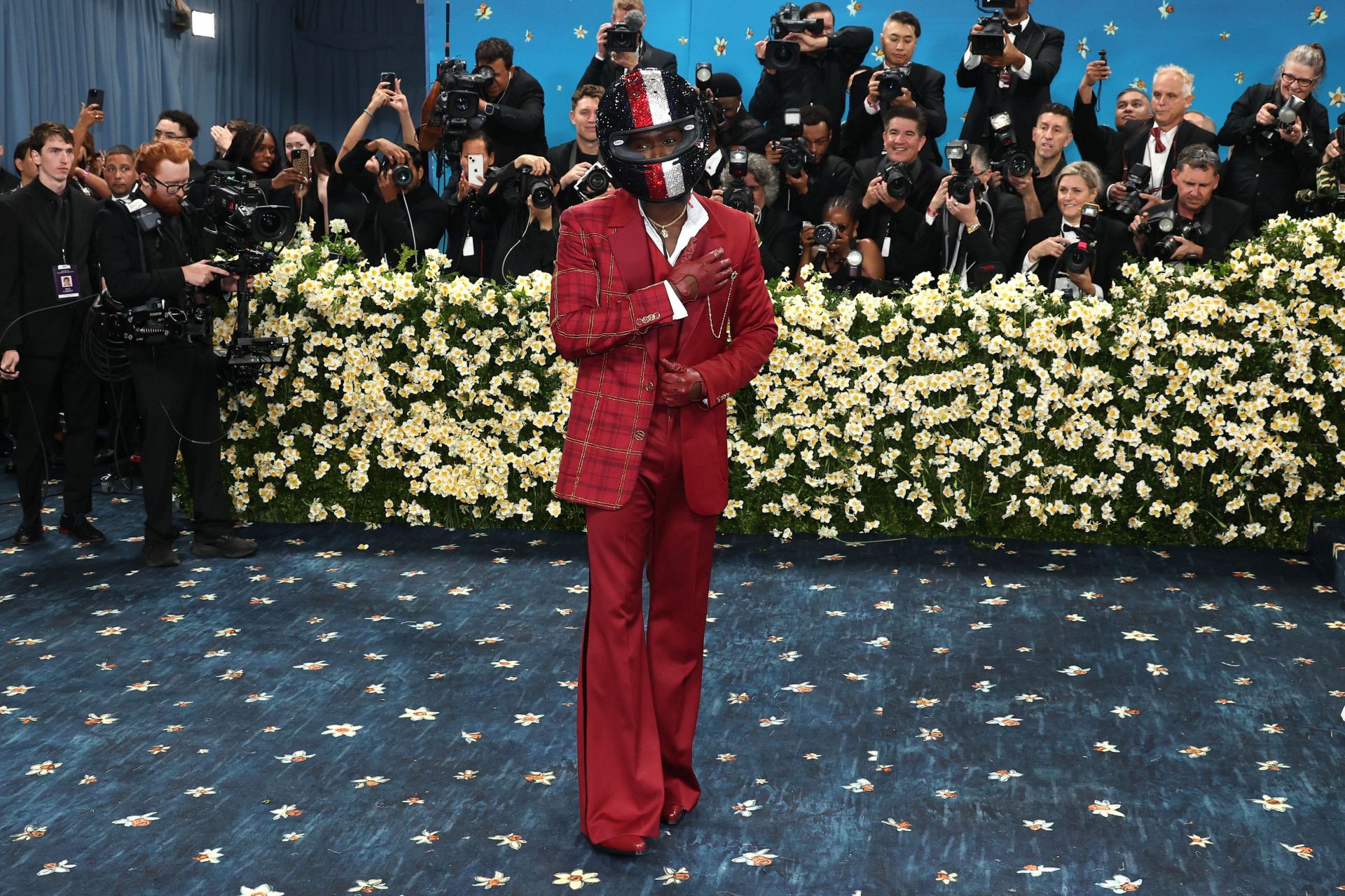 Damson Idris, actor revelación de la película 'F1' (protagonizada por Brad Pitt), lució uno de los estilismos más llamativos. Haciendo alusión a su papel, llevó un  casco rojo, blanco y azul adornado con cerca de 20.000 cristales de Swarovski colocados a mano. Eligió un look de Tommy Hilfiger compuesto por un esmoquin rojo que ofrecía una versión contemporánea del tartán Tommy, creado originalmente en el año 2000. 