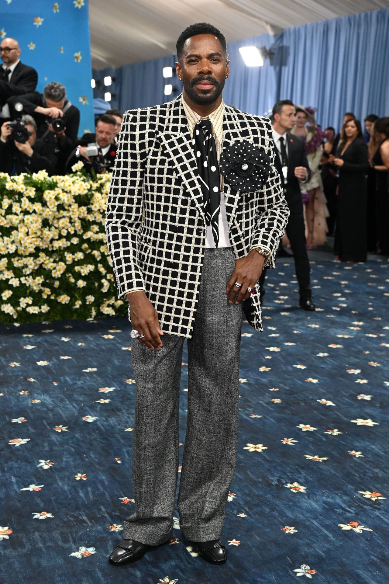 Colman Domingo derrochó glamour con un pantalón de lana en color gris que combinó con americana de cuadros, camisa de rayas, corbata de lazo con lunares y gran flor en la solapa. 