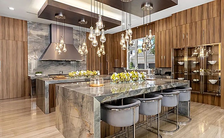 Imagen principal - La casa cuenta con una habitación de vinos, y un vestidor decorado como una boutique de Chanel. La cocina es de mármol y madera. 