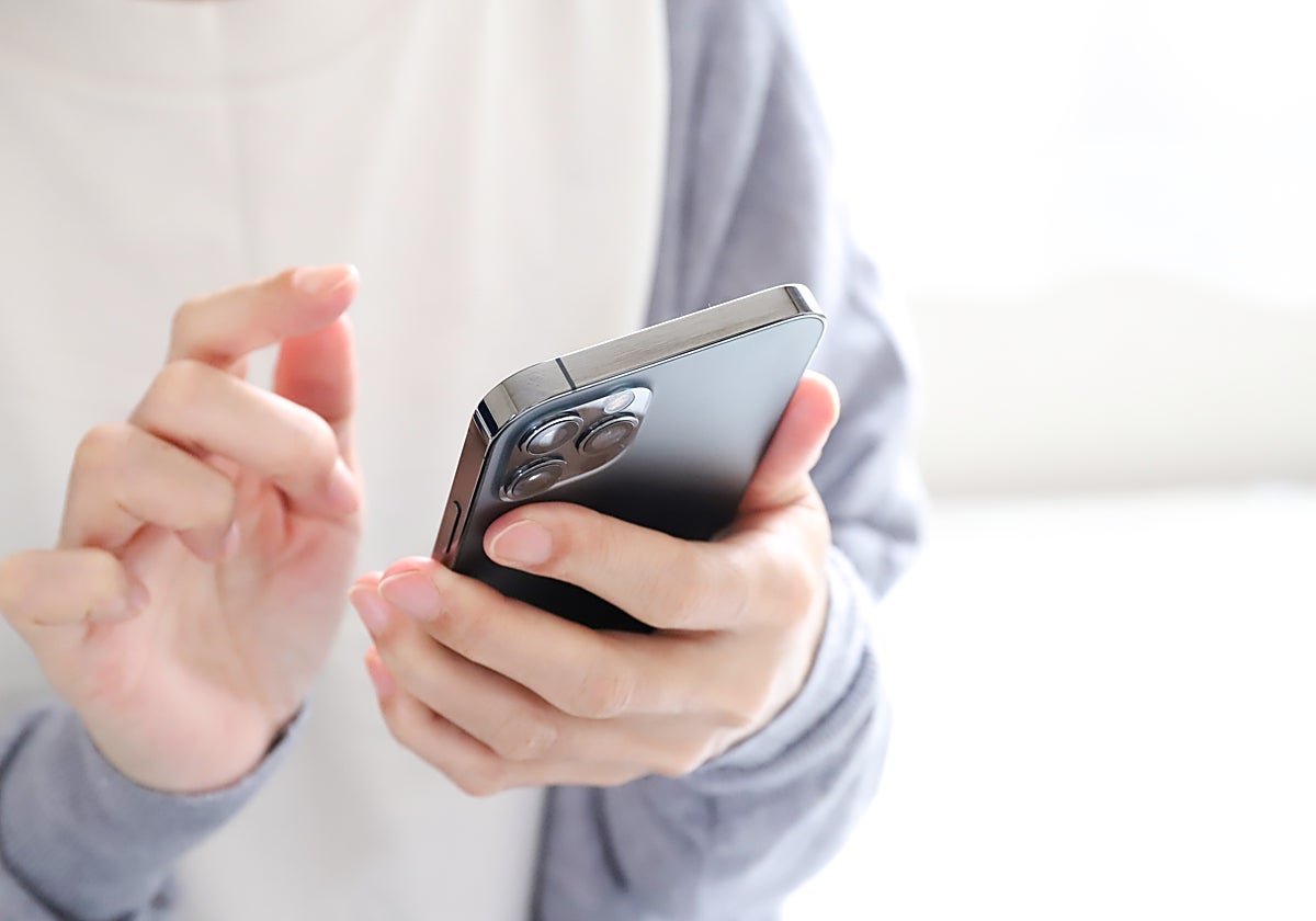 Fotografía de archivo de una mujer sosteniendo un móvil