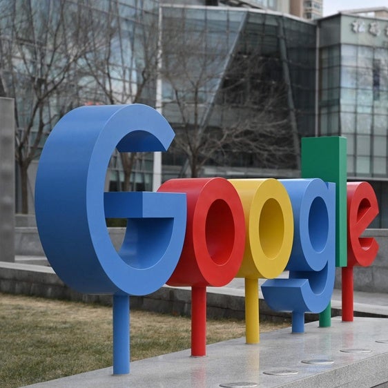 Un grupo de personas pasa junto a un logotipo de Google en el exterior de un edificio que alberga oficinas de Google en Pekín